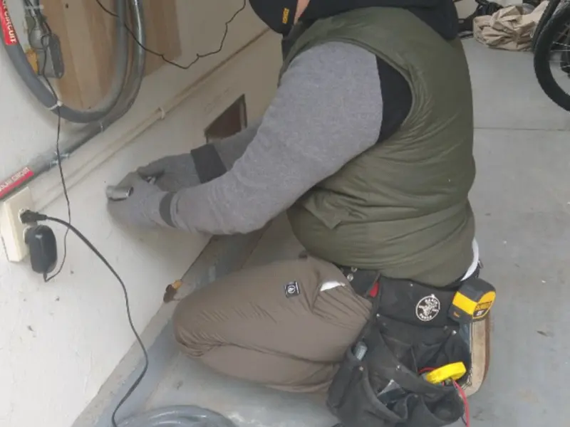 Electrician performing outlet wiring in a Freeport garage
